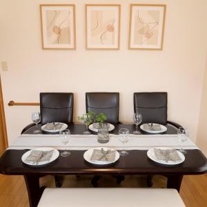 a dining room table with four chairs and glasses on it at Matsumoto BASE in Matsumoto