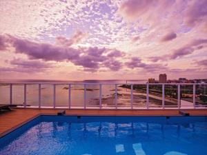 Ein Swimmingpool auf dem Dach eines Gebäudes mit Blick auf das Meer in der Unterkunft oile by Zayra Resorts in Chatan