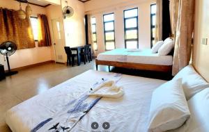 a hotel room with two beds with towels on them at Ondue Hotel & Events Place in Camalig