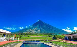 a mountain in the distance with a pool in front at Ondue Hotel & Events Place in Camalig