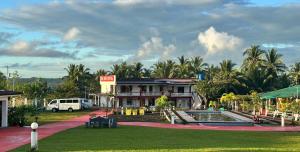 a resort with a pool in front of a building at Ondue Hotel & Events Place in Camalig