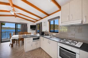a kitchen and dining room with a view of the ocean at Reflections Burrinjuck Waters - Holiday Park in Bookham