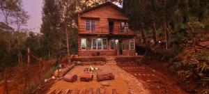 a log house with a fire in front of it at Mộc Tín Farmstay in Lạc Dương