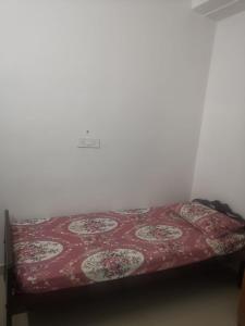 a bed in a room with a red blanket at Railviewtouristhome in Varkala