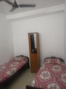 a room with two beds and a door in it at Railviewtouristhome in Varkala