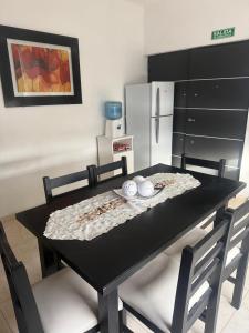 a black table with two chairs and a refrigerator at Acordes de Gaitas - Departamento 2 in Malargüe