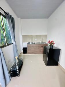 a kitchen with a black refrigerator in a room at Sol caribe aptos in Santiago