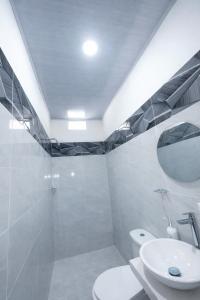 a white bathroom with a sink and a mirror at Sol caribe aptos in Santiago