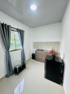 a living room with a large window and a kitchen at Sol caribe aptos in Santiago