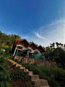 a house on a hill with stairs in front of it at Forest River Escape Ella in Ella