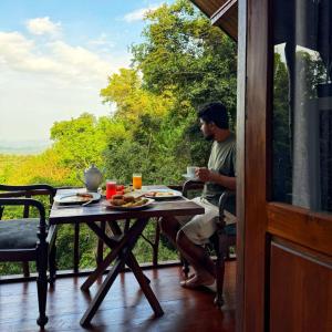 a man sitting at a table on a porch at Forest River Escape Ella in Ella