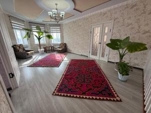 a living room with two rugs on the floor at Tunduk House14 in Bash-Kayyngdy