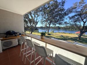a kitchen with a counter with chairs and a large window at Sussex View - Waterfront Couples Retreat in Sussex Inlet in Sussex Inlet