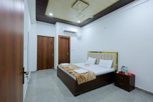a bedroom with a large bed with a wooden headboard at Omji Ashram - Ramnagar 10 min from Shri Banke Bihari Temple in Vrindāvan