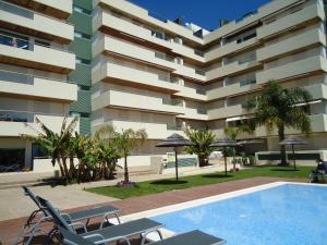 a swimming pool in front of a building at Marina Vilamoura Apartment in Vilamoura