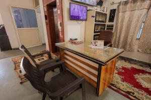 a room with a desk and a chair and a television at Omji Ashram - Ramnagar 10 min from Shri Banke Bihari Temple in Vrindāvan +24 photos