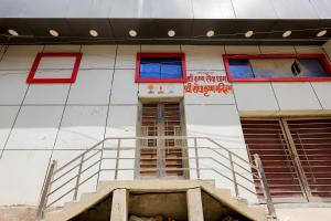 a building with red and blue windows and a staircase at Omji Ashram - Ramnagar 10 min from Shri Banke Bihari Temple in Vrindāvan