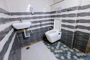 a bathroom with a toilet and a sink at Omji Ashram - Ramnagar 10 min from Shri Banke Bihari Temple in Vrindāvan