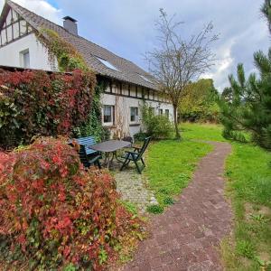 a house with a table and benches in the yard at Mammut Cottage in Balve