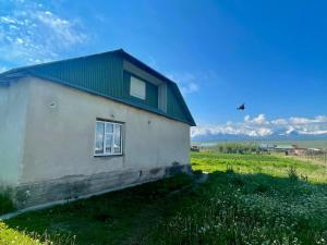 a small building with a green roof in a field at Ali guest house in Sary-Mogul