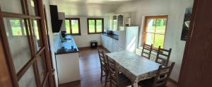 a kitchen and dining room with a table and a refrigerator at Mammut Cottage in Balve