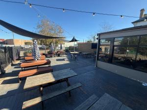 a patio with benches and tables and a tent at Imperial Hotel Singleton in Singleton