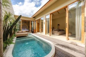 an indoor pool with a deck and a house at 1 BR Private Pool Villa for Two - Casa Manja in Krambitan