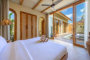 a teddy bear sitting on a bed in a bedroom at 1 BR Private Pool Villa for Two - Casa Manja in Krambitan