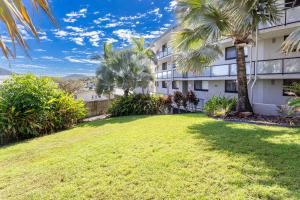 a large yard in front of a building with palm trees at Sea Air 2 in Yeppoon