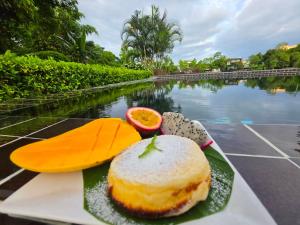 a plate of food on a table next to a body of water at i-river chiangmai in Chiang Mai
