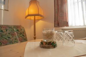 a table with a glass jar with a teddy bear in it at Pension Haus Marga in Wernigerode