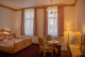 a bedroom with a bed and a table and chairs at Pension Haus Marga in Wernigerode