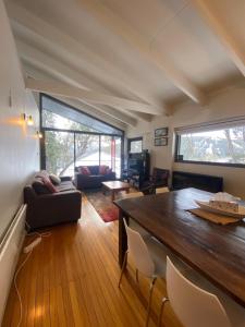 a living room with a large wooden table and chairs at Alana Apartment 2 in Falls Creek