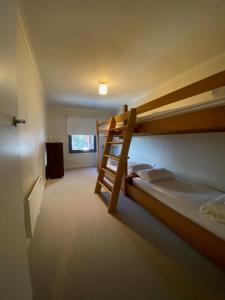 a bedroom with two bunk beds and a television at Alana Apartment 2 in Falls Creek