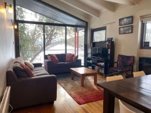 a living room with a couch and a table at Alana Apartment 2 in Falls Creek