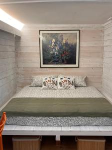 a bed in a room with a painting on the wall at Jasmine & Rose House in Udine