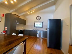 a kitchen with a black refrigerator and a table at Alana Apartment 2 in Falls Creek +5 photos