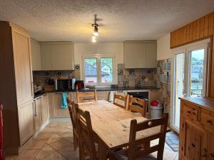 a kitchen with a wooden table and chairs in it at Le Central - Chambres d'hôte in Grône +27 photos