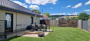 a backyard with a table and chairs and a fence at Ferienhaus Alex in Gönnersdorf