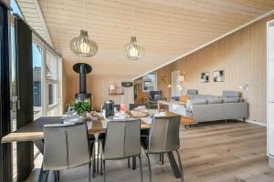 a dining room and living room with a table and chairs at C11326-Tarm-Sortbaervej-20 in Tarm