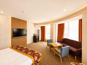 a hotel room with a bed and a couch at Margad Hotel in Ulaanbaatar