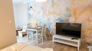 a living room with a tv and a table with chairs at Apartamenty ADM in Poznań