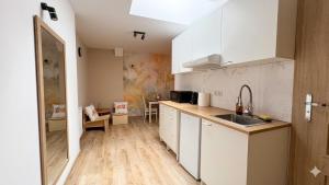 a kitchen with white cabinets and a counter top at Apartamenty ADM in Poznań