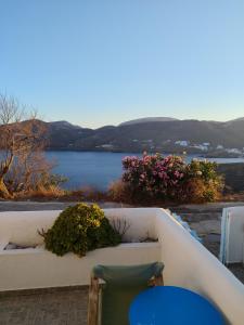 a table and chairs on a patio with a view of a lake at ASVESTOTI MESONETTES BLUE LIGHT ΣΙΕΛ ΜΕΖΟΝΕΤΕs in Pera Gyalos