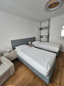 a bedroom with two beds and a couch at Apartmány Baťovany in Partizánske