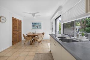a kitchen with a sink and a table with chairs at Suntan at Sunshine in Sunshine Beach