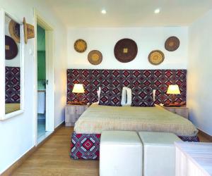 a bedroom with a bed and some plates on the wall at Guesthouse MALAGUETA INN II in Maputo