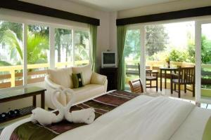 a bedroom with a large bed and a living room at Bacchus Home Resort Pranburi in Ban Pak Nam Pran