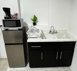 a kitchen with a sink and a microwave at Deluxe noir Loft cerca de parque fundidora in Monterrey