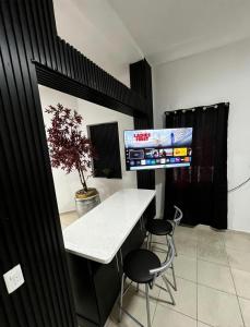 a room with a table and two chairs and a tv at Deluxe noir Loft cerca de parque fundidora in Monterrey